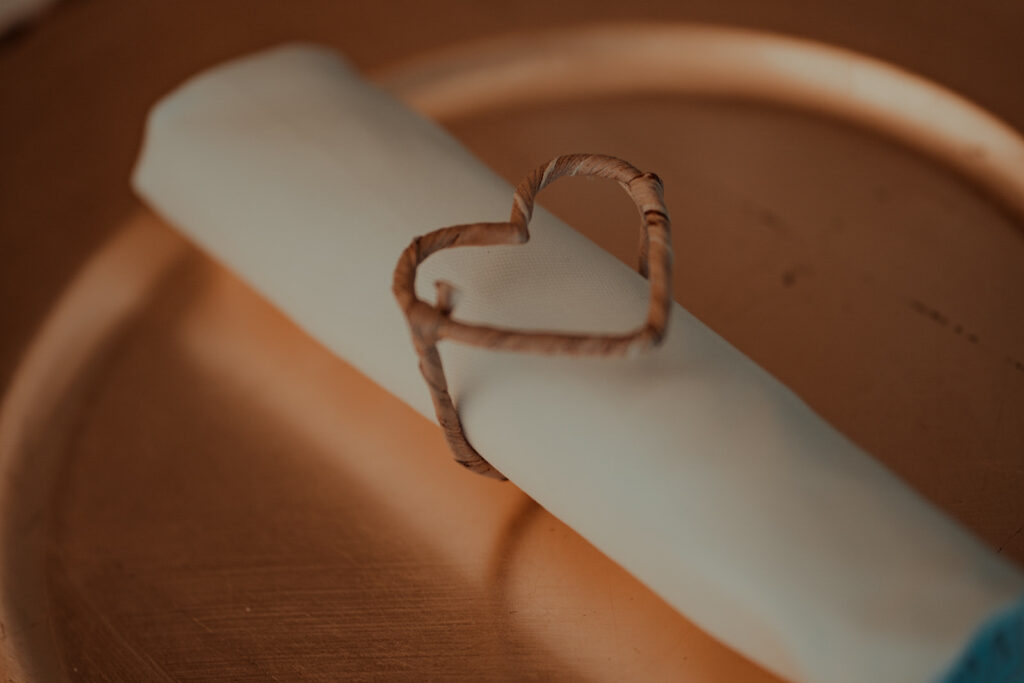 Tischdekoration weiße Serviette mit Serviettenring in Herzform