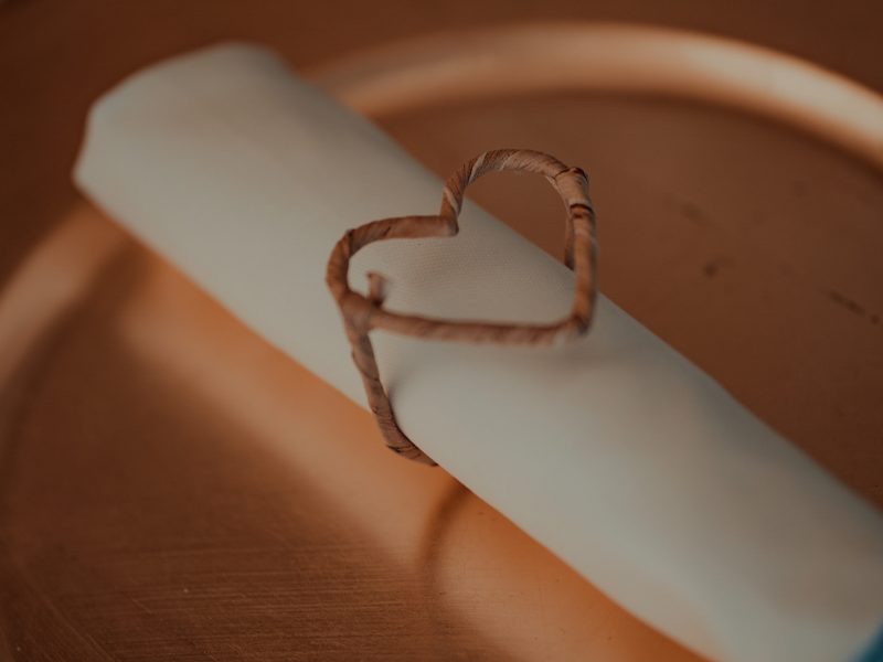 Tischdekoration weiße Serviette mit Serviettenring in Herzform